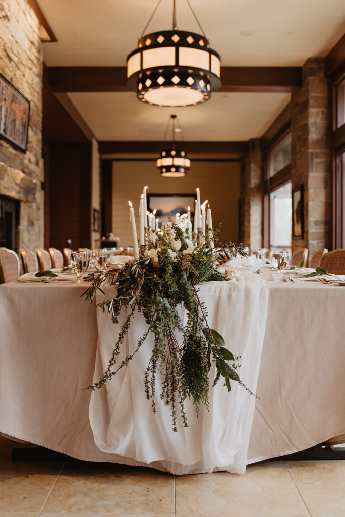 wedding reception tables with winter foliage and tall white candles