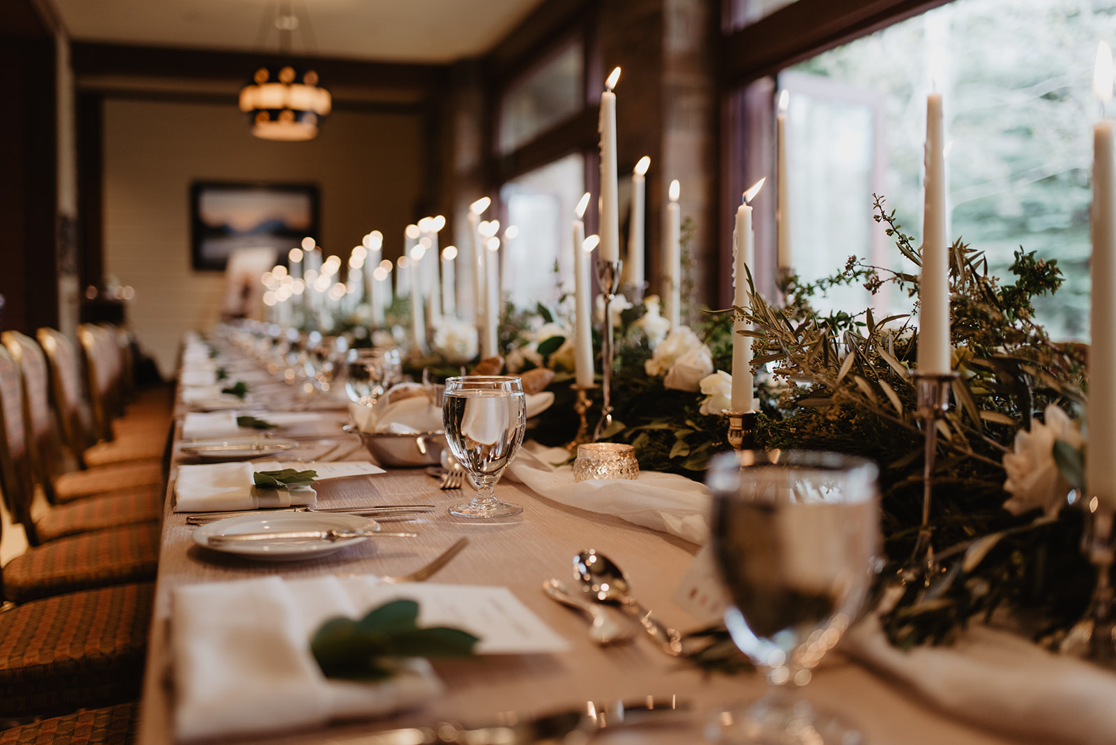 tall candles and lush greenery for a table centerpiece for wedding reception at Four Seasons Jackson Hole