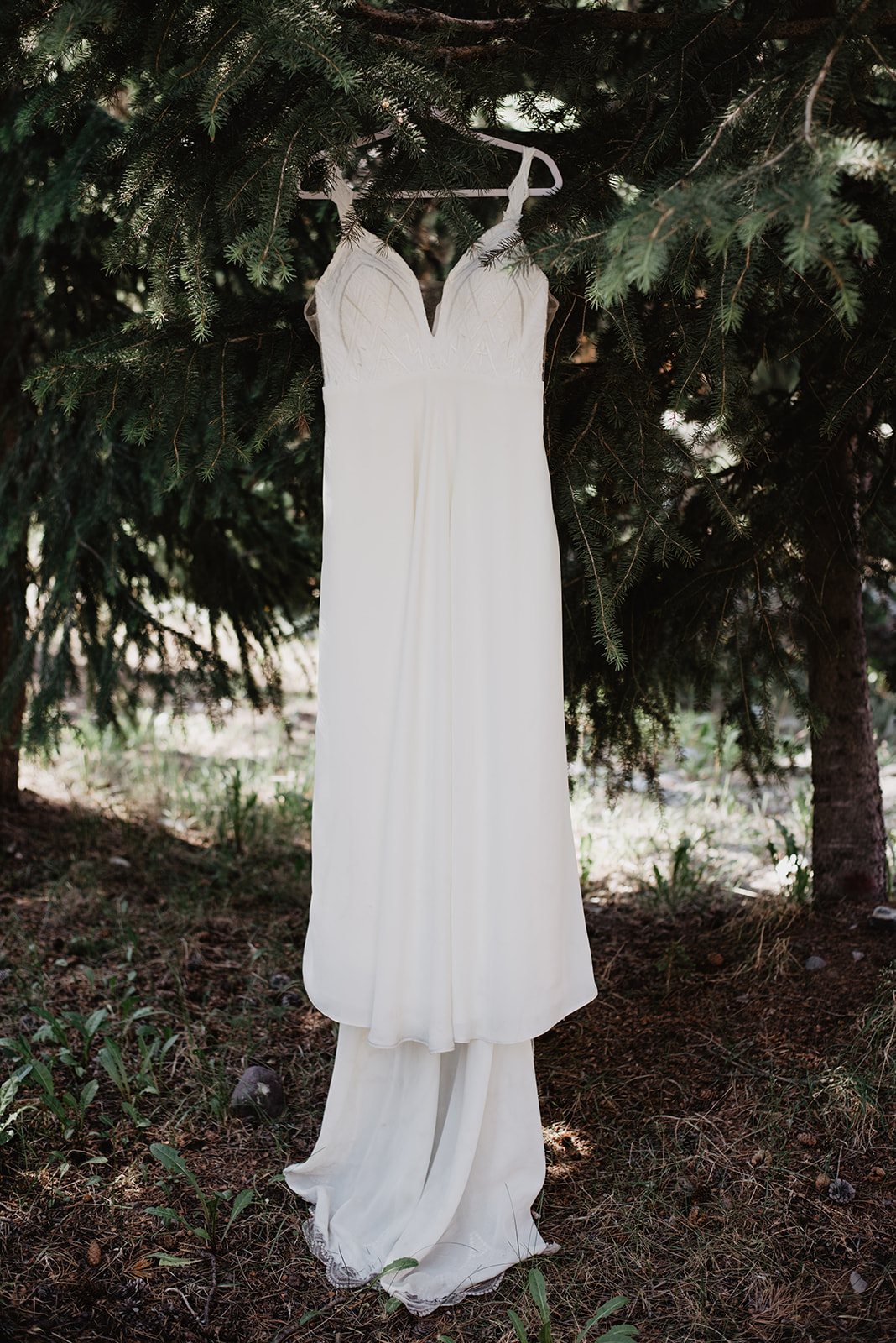 custom made wedding dress hanging from a tree in Jackson Hole for a detai lshot