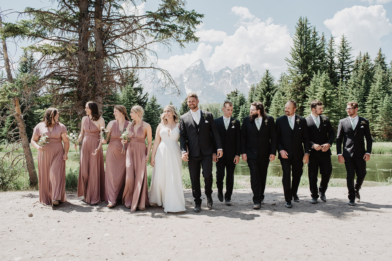 bridal party in a line walking towards the camera together in Jackson Hole elopement spot