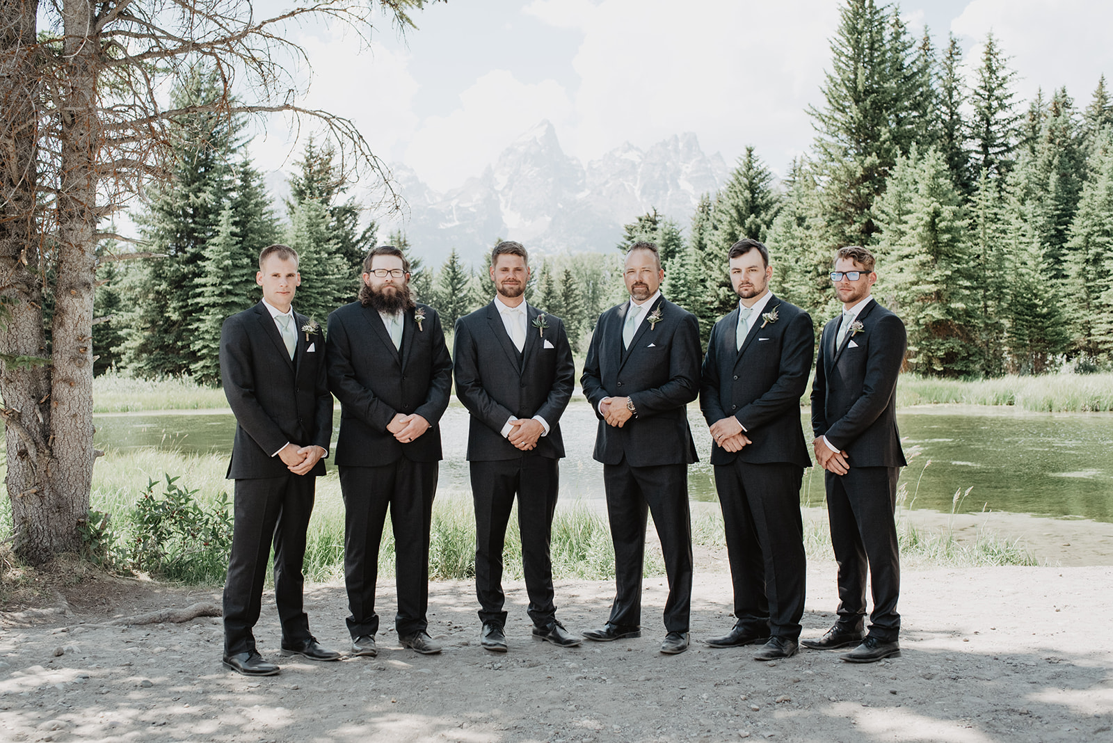 groomsmen standing together in the Tetons posing for wedding photos