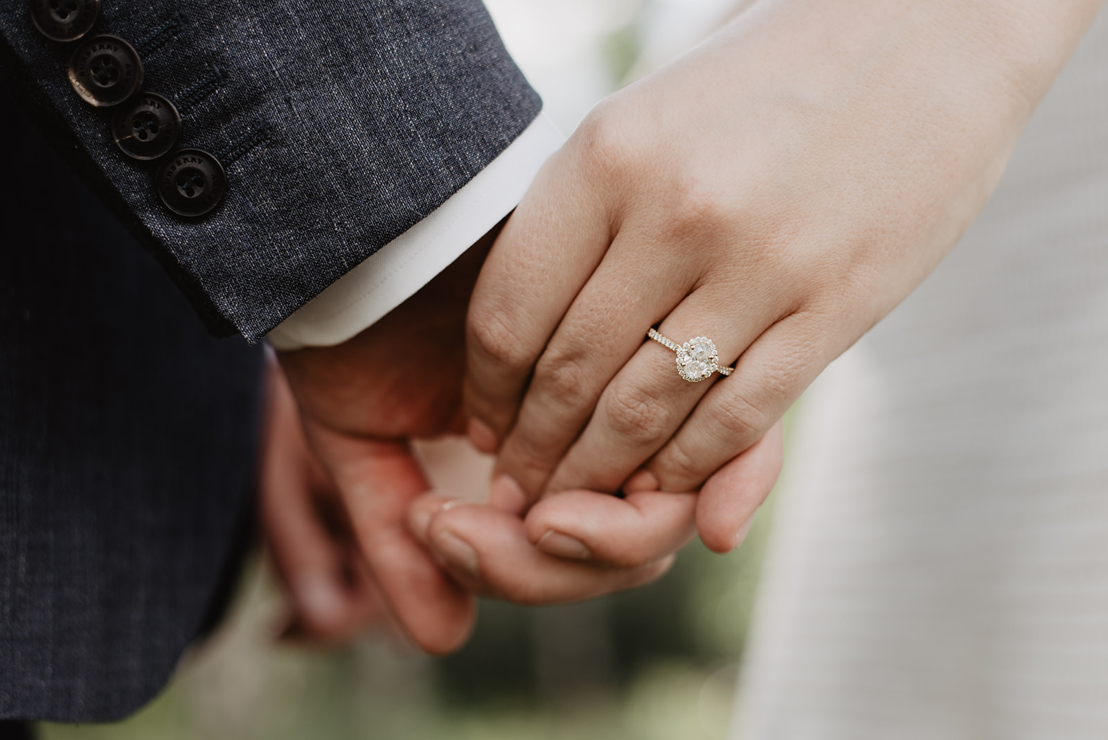 detail shot of engagement ring as bride and groom hold hands in the Grand Tetons