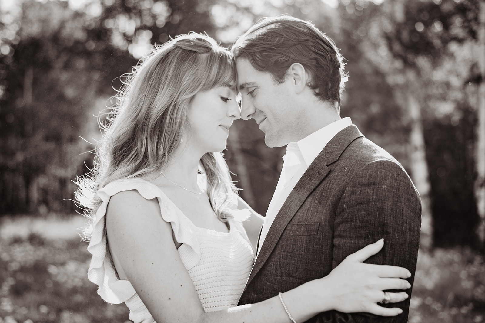 black and white engagement photo of man and woman embracing in a field in Jackson Hole for their Jackson Hole photo tour engagement session