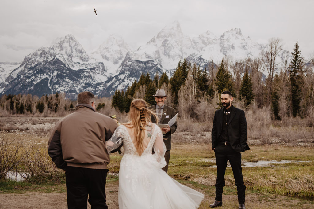 bride's father walking her down the aisle to her groom in the Tetons for her Jackson Hole wedding venue