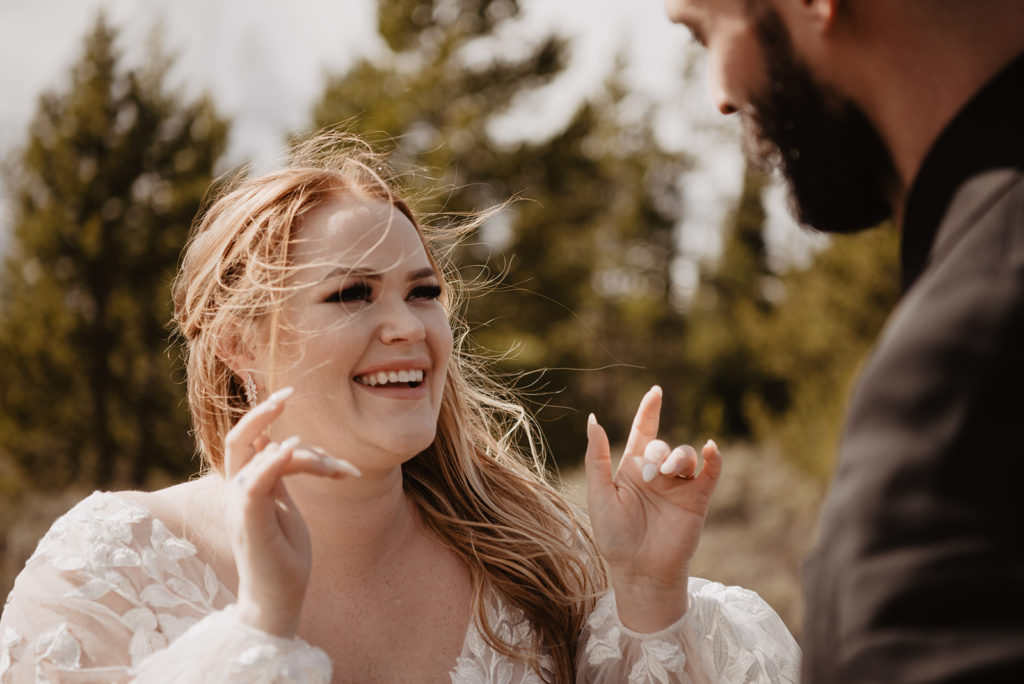 bride smiling and laughing with her groom in the woods for their Jackson Hole wedding 