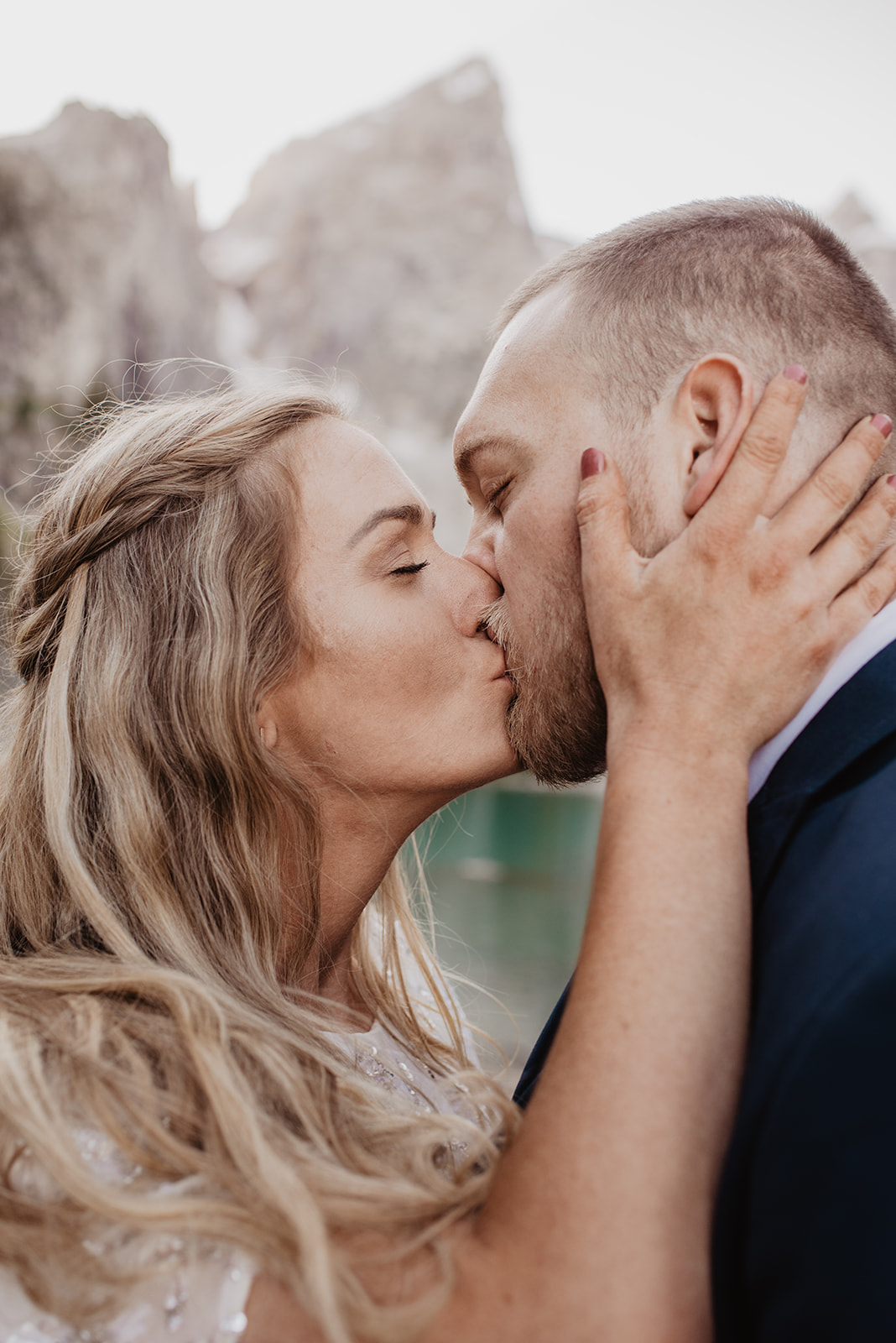 Jackson Hole wedding pictures in Grand Tetons with bride and groom kissing while the bride holds the grooms face photographed by Jackson Hole wedding photographers 