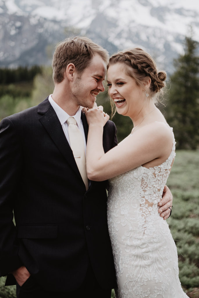 outdoor bridal photos taken by Jackson Hole wedding photographer of bride and groom embracing each other in front of the mountains for their outdoor wedding