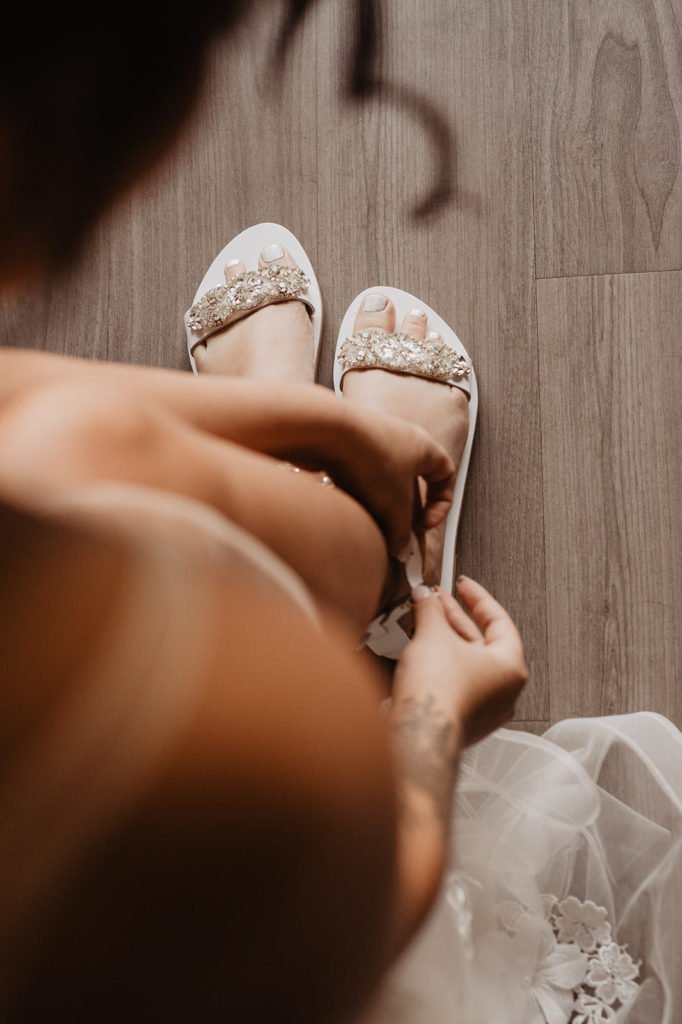 Utah elopement photographer captures bride putting on her wedding shoes in her bridal suite for elopement getting ready pictures