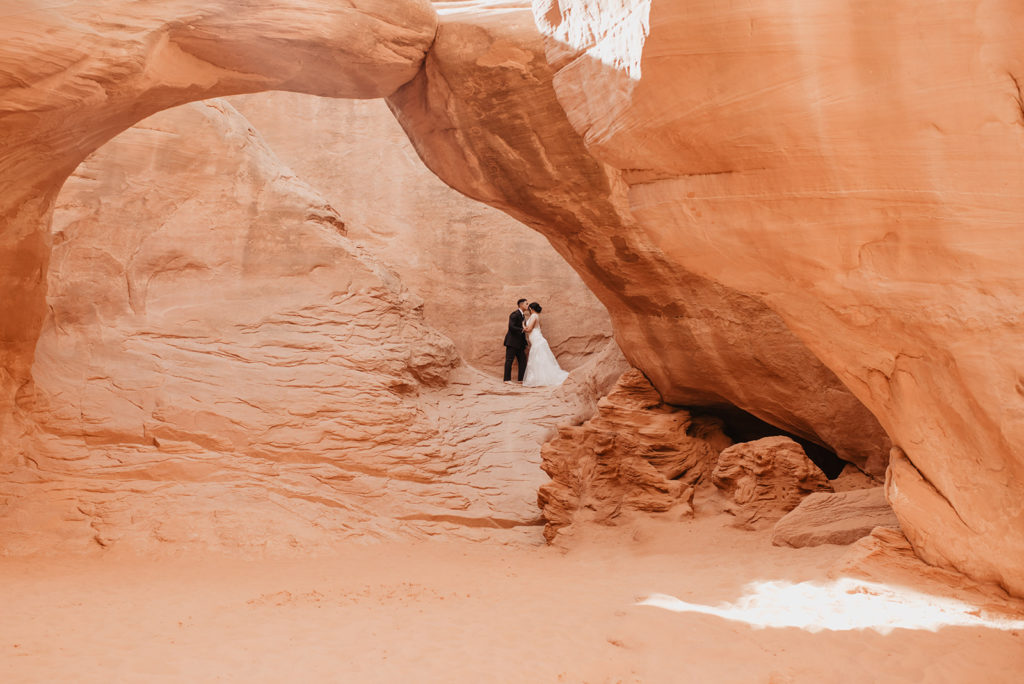 Utah elopement photographer captures couple kissing under arches 