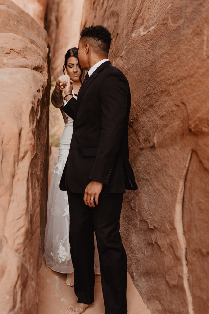 Utah elopement photographer captures bride and groom holding hands while walking