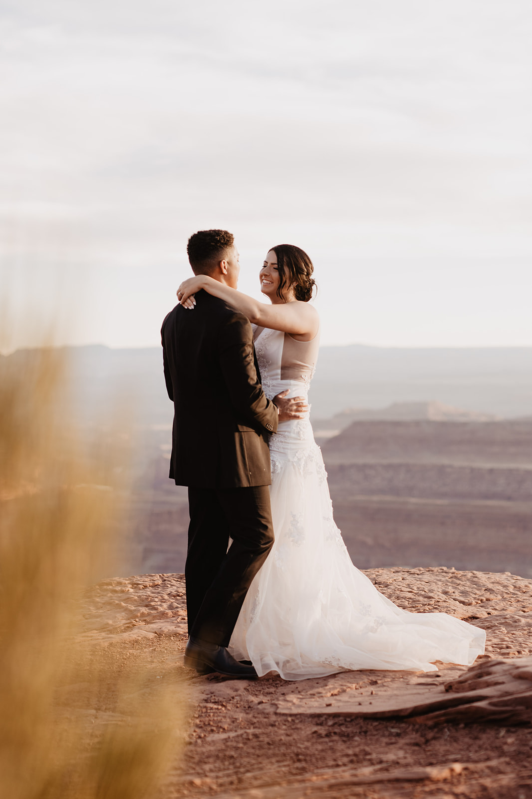 bride and groom dancing on a mountain top for their Arches National Park wedding captured by utah elopement photographer