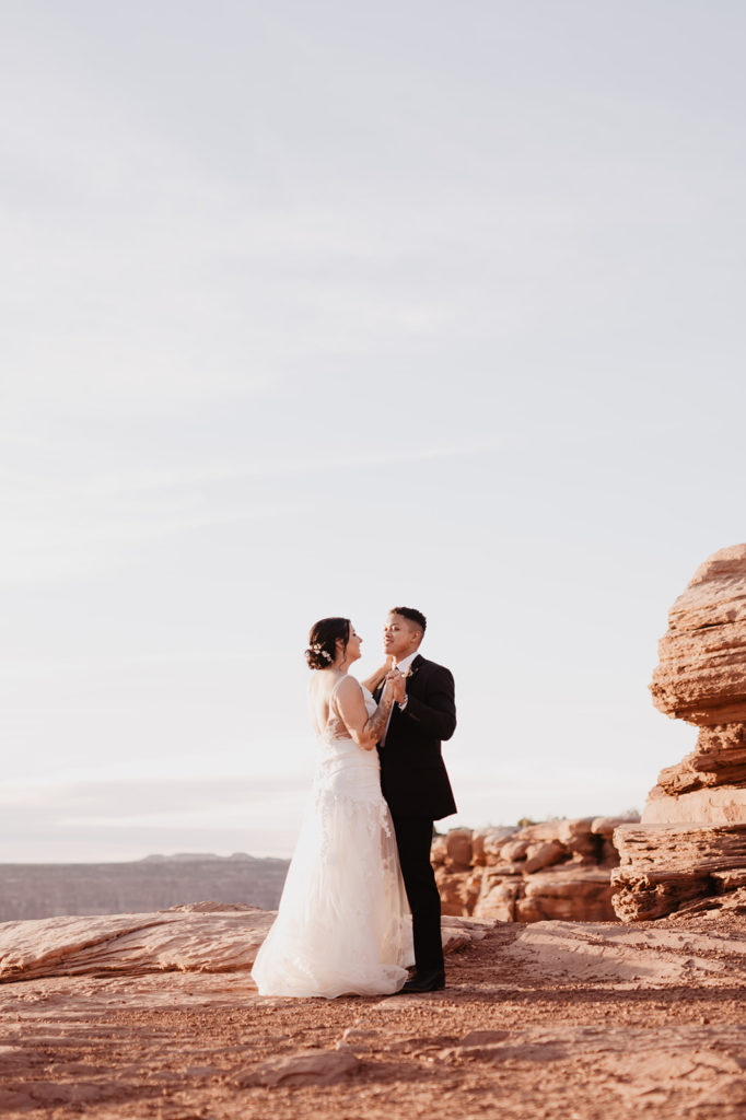 Arches National Park wedding with bride and groom dancing on a mountain top over looking the red rocks at sunset with Utah elopement photographer 