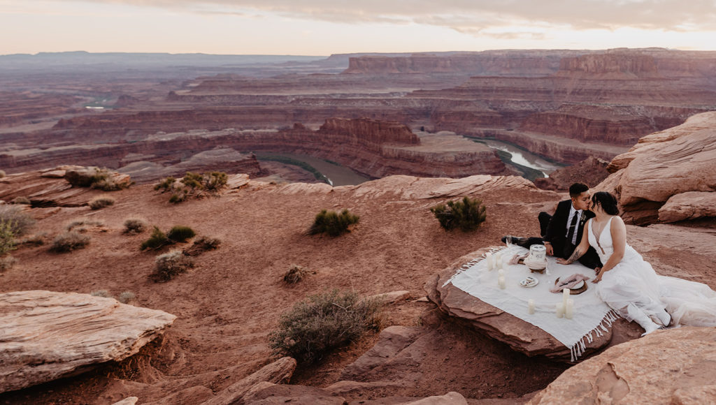 Utah Elopement Photographer captures bride and groom sitting on picnic blanket 