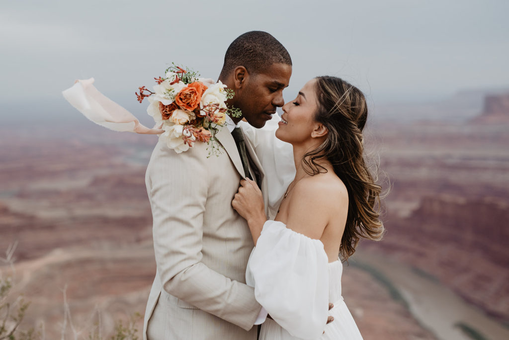 outdoor bridals in Arches National Park with Utah elopement photographer capturing bride and groom leaning into each other intimately for their outdoor wedding 