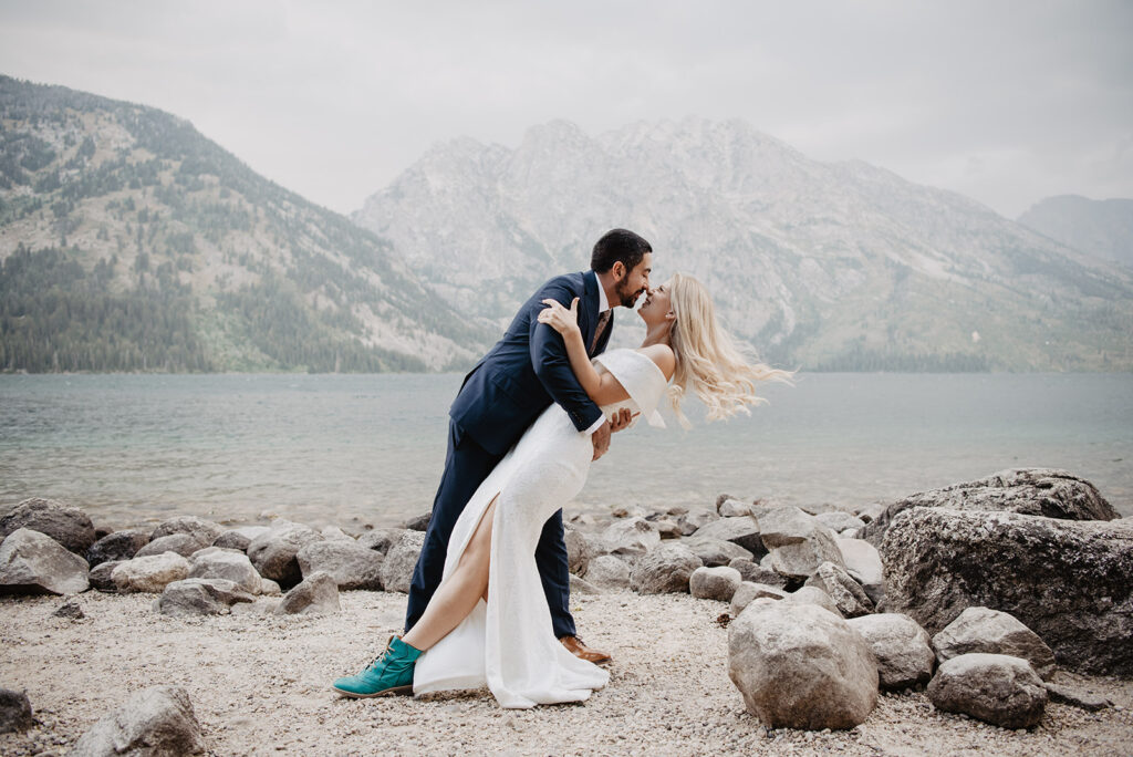 Jackson Hole photographers capture groom dipping his bride backwards for a kiss on her forehead captured by grand teton photographer