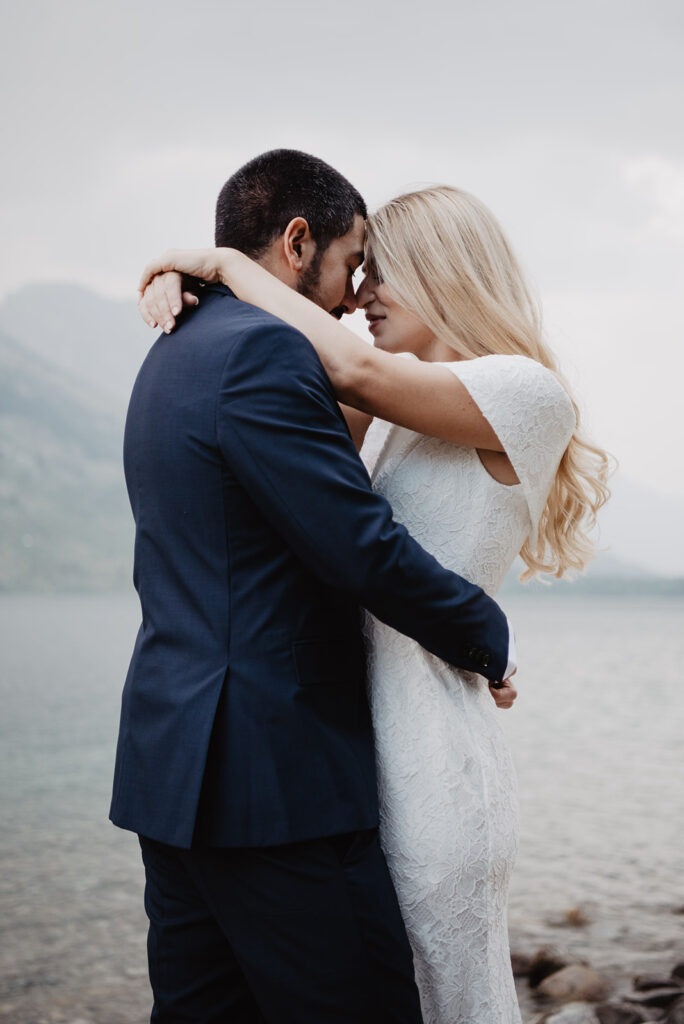 romantic Grand Teton wedding photos with bride and groom embracing one another as their foreheads rest on one another captured by jackson hole photographers