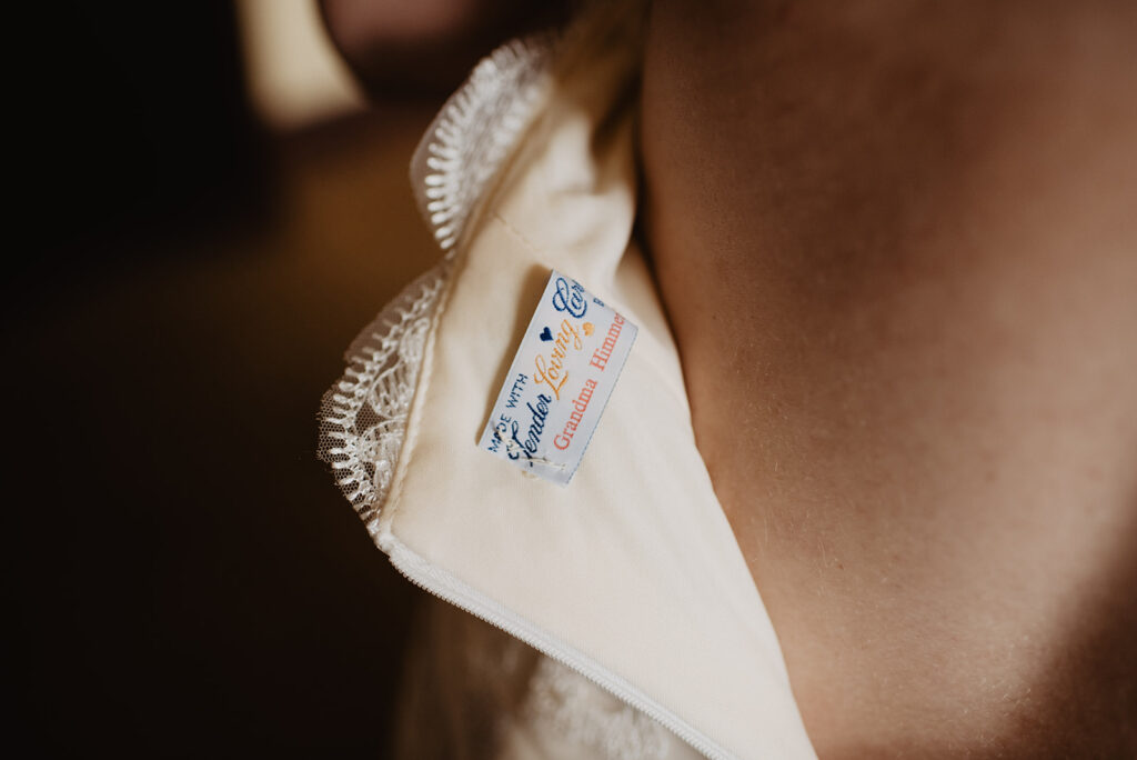 jackson hole photographers captures meaningful detail of brides wedding dress tag with embroidery from her grandmother