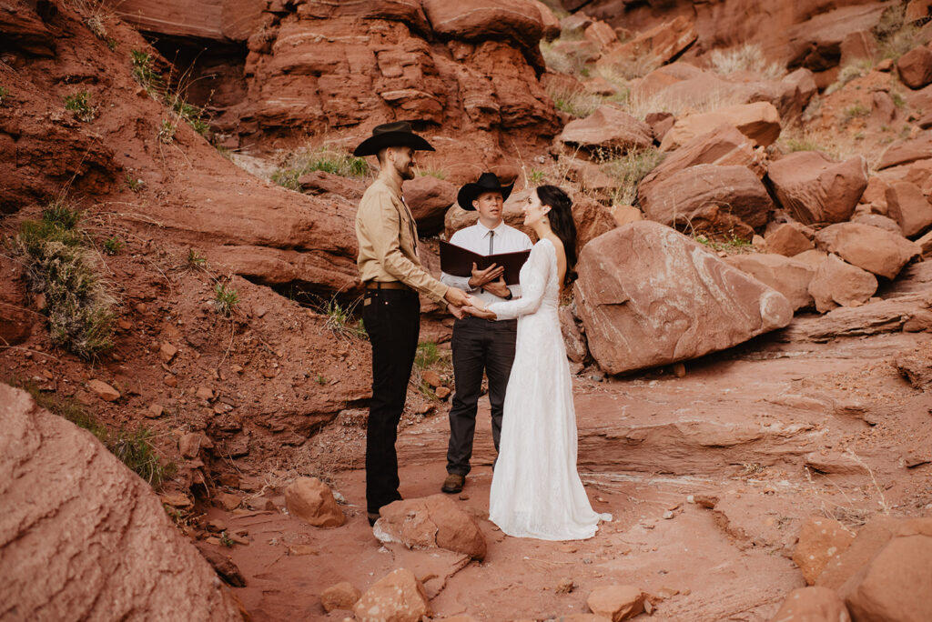Utah elopement photographer captures couple holding hands during Moab elopement ceremony