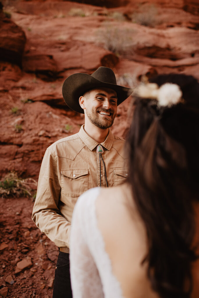 Utah elopement photographer captures groom smiling at bride during Moab elopement