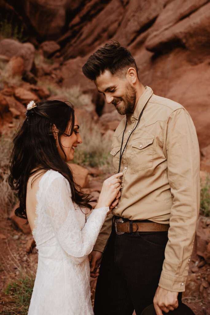 Utah elopement photographer captures bride helping groom button shirt