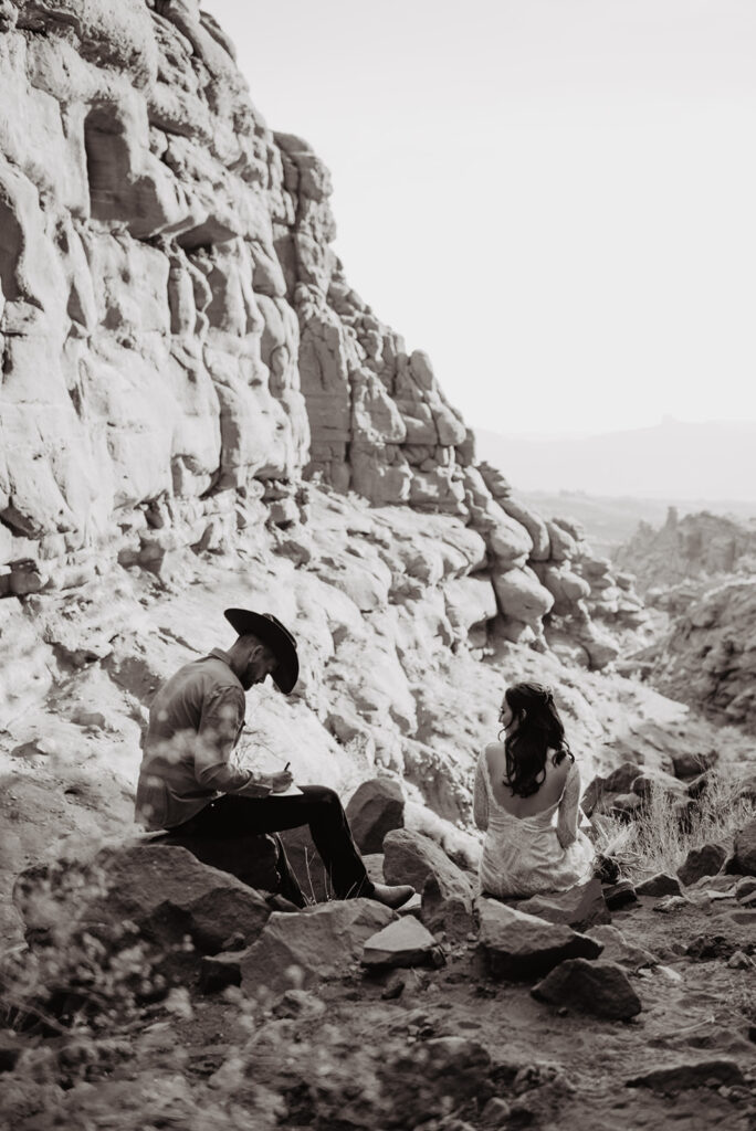 Utah elopement photographer captures couple sitting in rocks in Moab after elopement planning