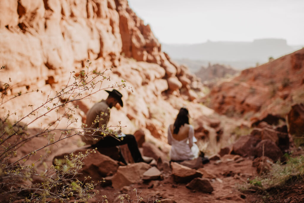 bride and groom sitting on rocks in the mountain of utah and writing their vows captured by utah elopement photographer