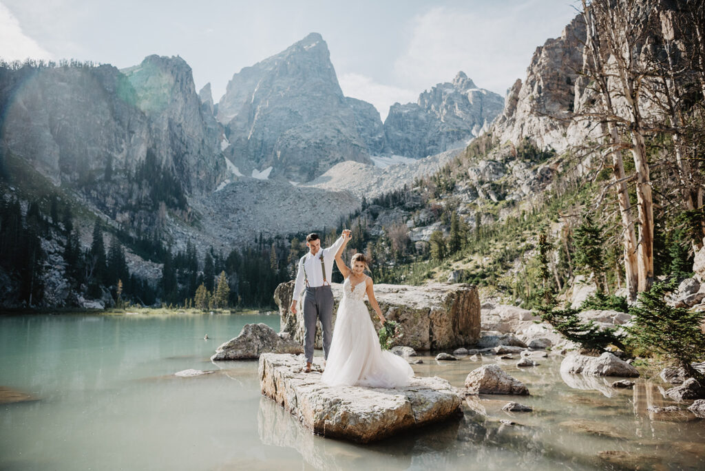 Jackson Hole Photographer captures bride and groom spinning on rock in Jackson Hole