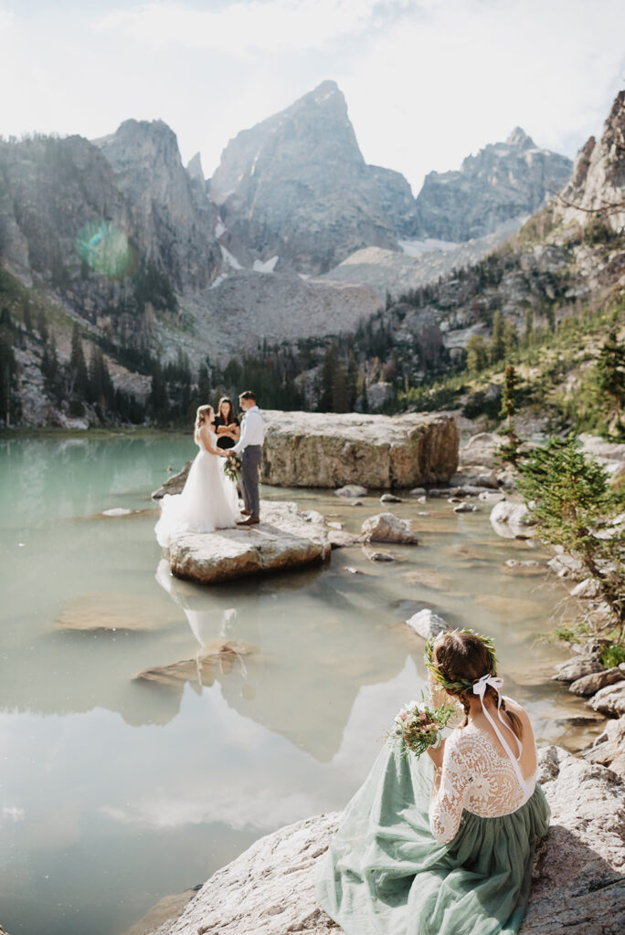 Jackson Hole photographer captures bride and groom holding hands during ceremony
