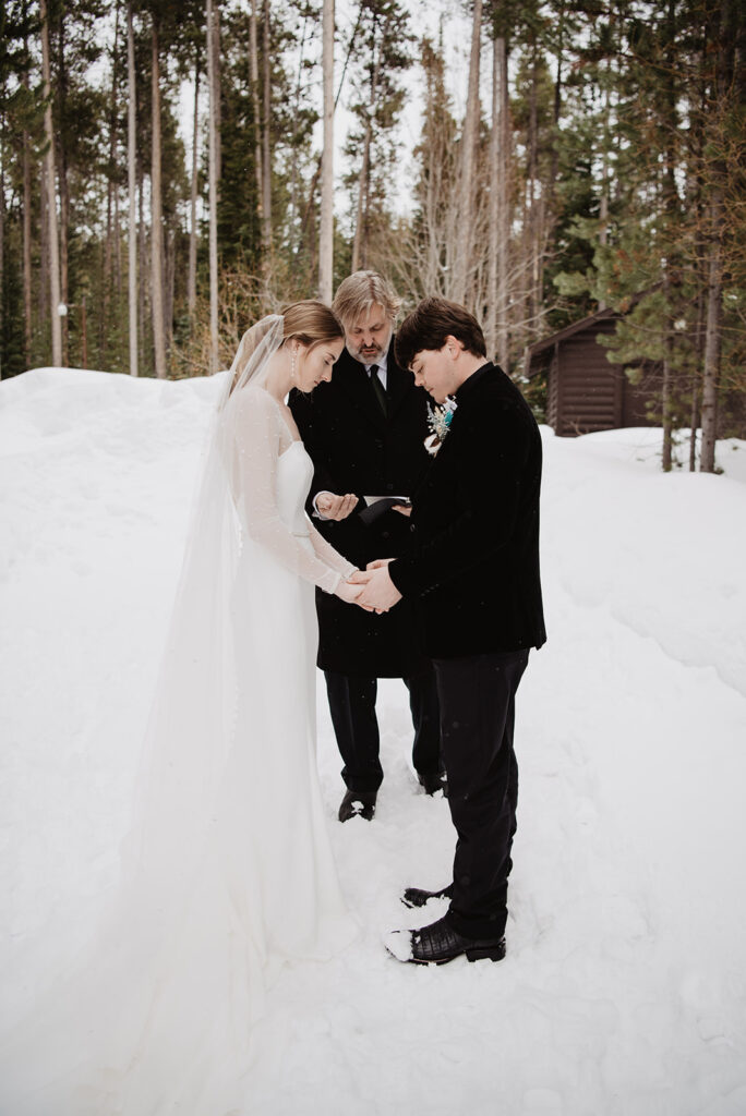 Grand Teton photographer captures bride and groom holding hands during ceremony