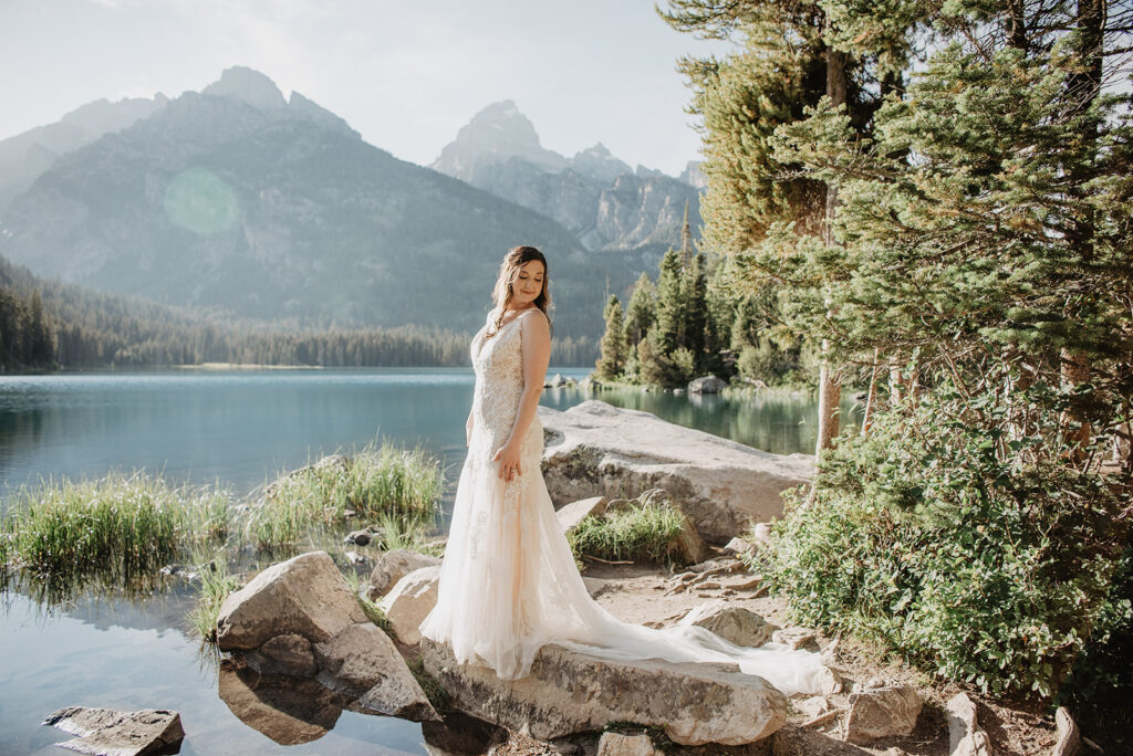 Jackson Hole wedding photographer captures bride standing on rock during bridal portraits