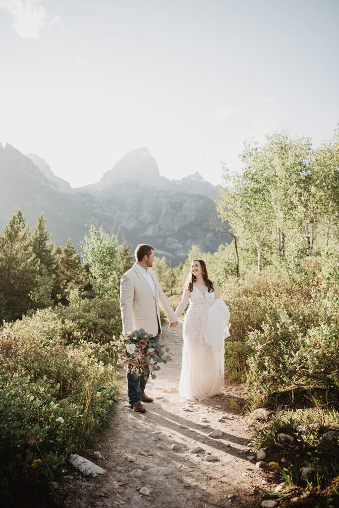 Jackson Hole wedding photographer captures bride and groom walking through Grand Teton National Park together