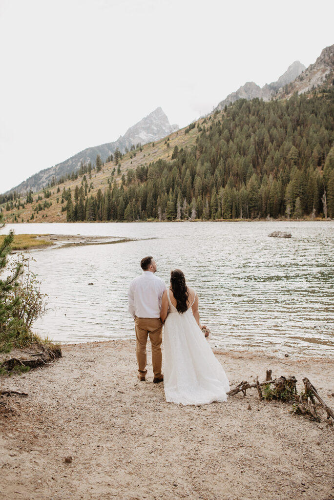 Photographers Jackson Hole capture newly married couple standing lakeside