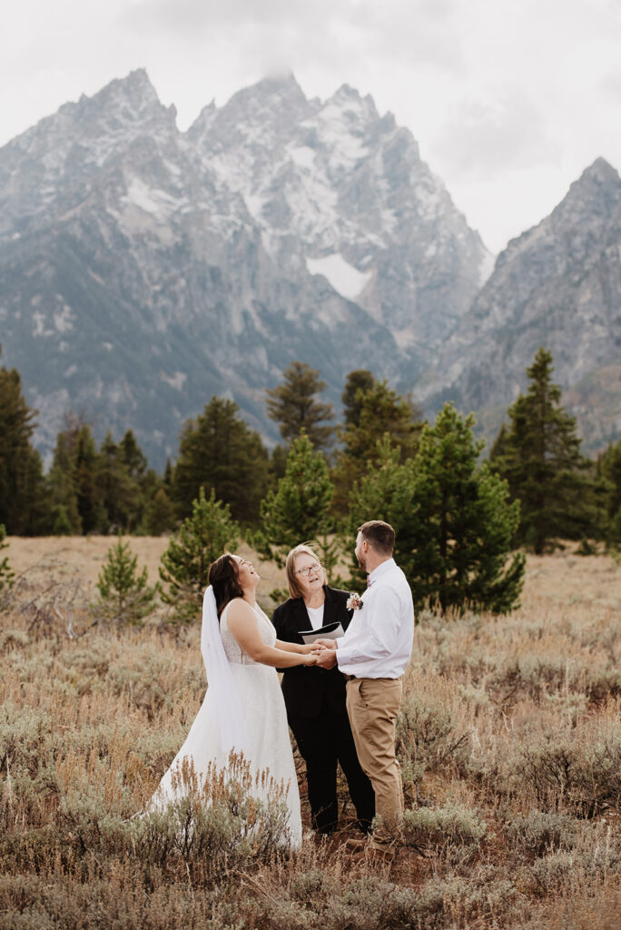 Photographers Jackson Hole capture bride and groom holding hands during elopement ceremony