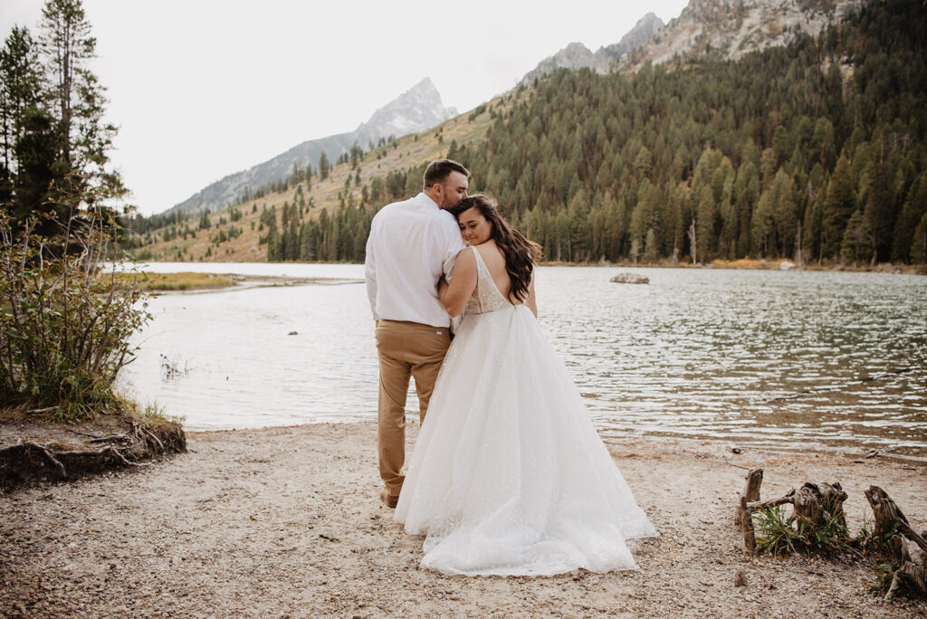 Photographers Jackson Hole capture bride hugging groom's arm
