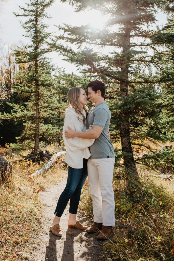 Jackson Hole Photographer captures newly engaged couple kissing in forest 