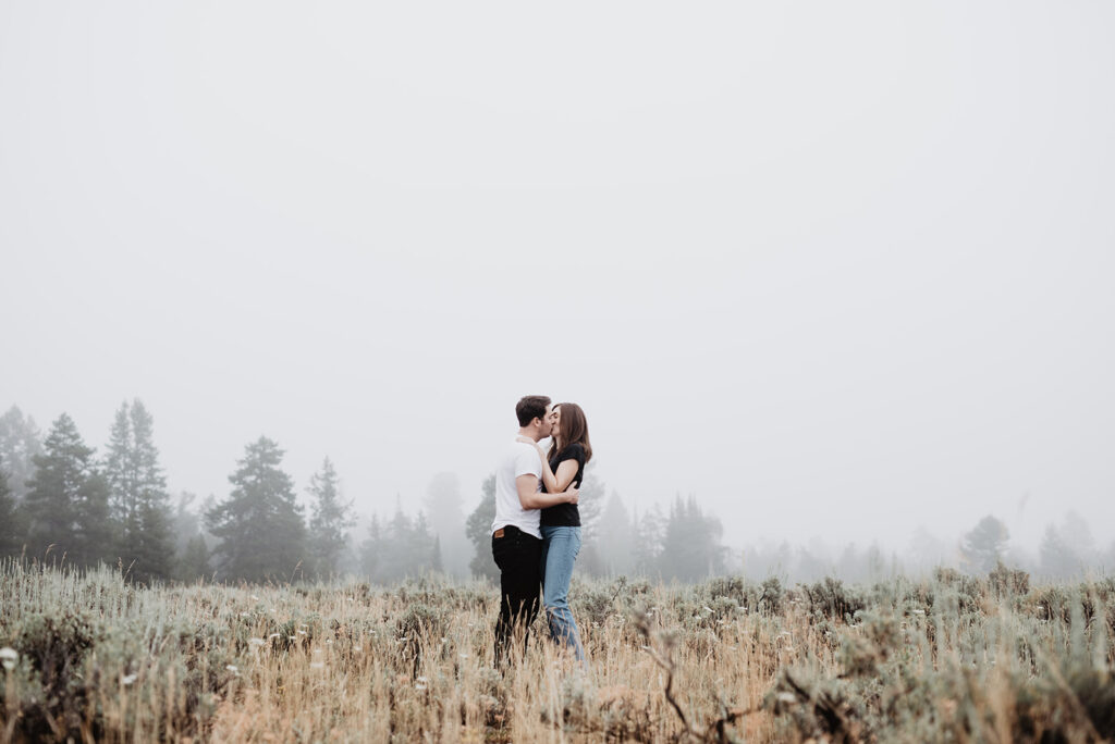 Jackson Hole Photographer captures couple kissing in meadow during engagement photos in Jackson Hole