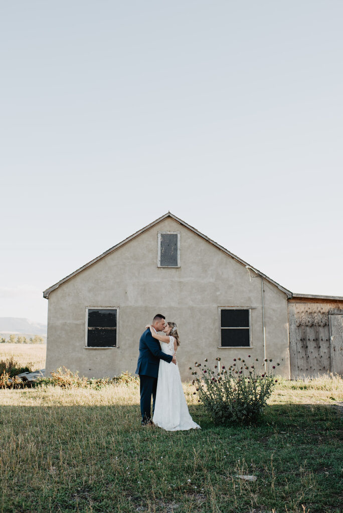 Photographers Jackson Hole capture couple embracing in front of barn after Jackson Hole wedding