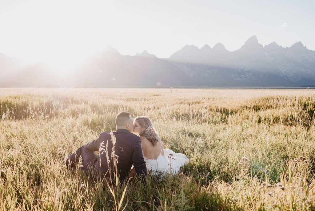 Photographers Jackson Hole capture couple sitting in grassy field together