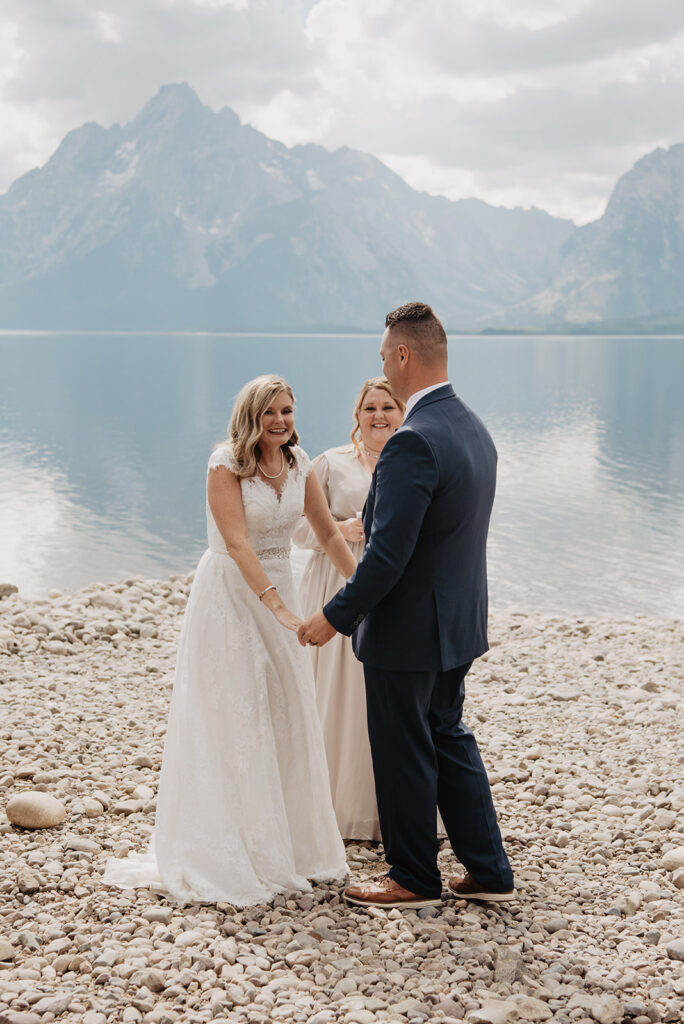 Photographers Jackson Hole capture bride holding hands with groom