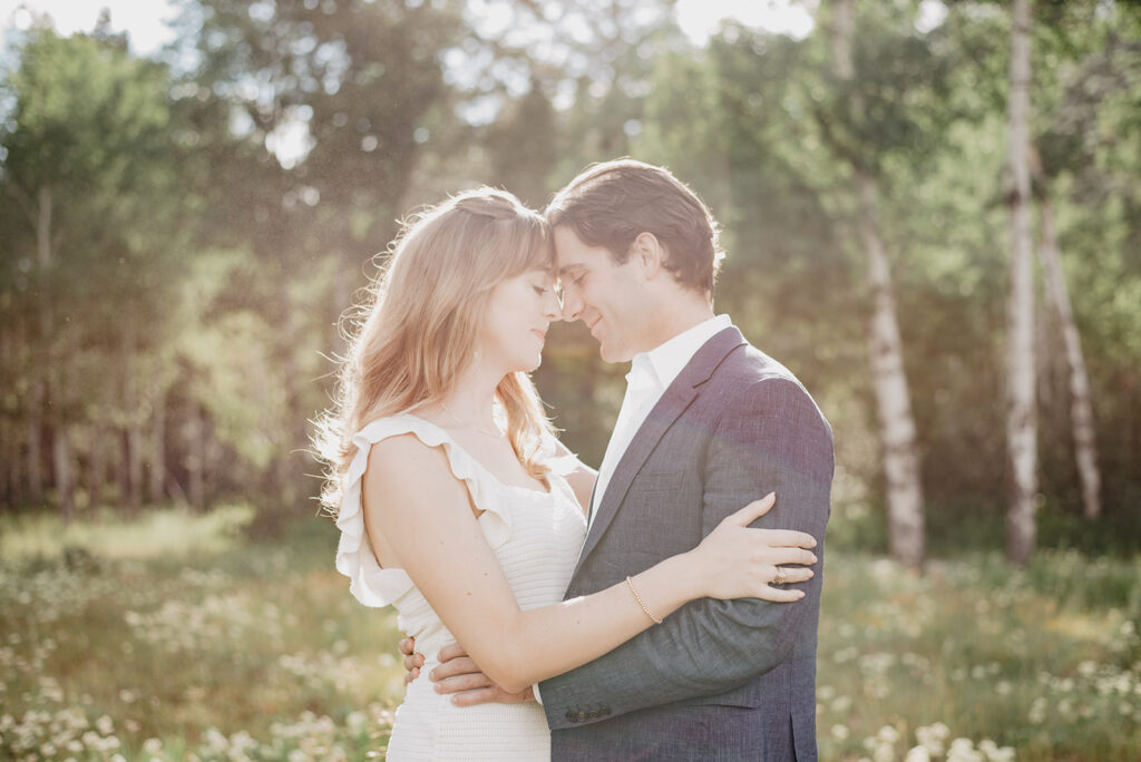 Jackson Hole Photographer captures couple embracing and touching foreheads during outdoor engagement session inJ Jackson Hole