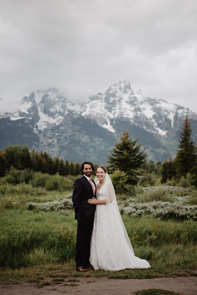 Jackson Hole wedding photographer captures bride with hand on groom's stomach during outdoor bridals