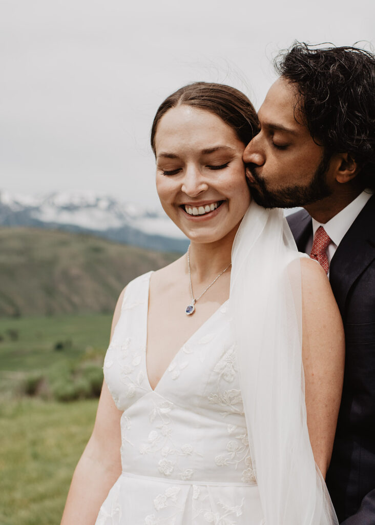 Jackson Hole wedding photographer captures groom kissing bride's cheek