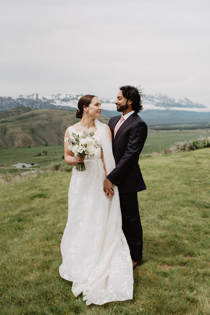 Jackson Hole Wedding Photographer captures couple looking at one another during bridal portraits after Amangani wedding