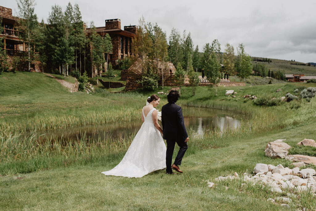 Jackson Hole wedding photographer captures bride and groom holding hands after amangani wedding