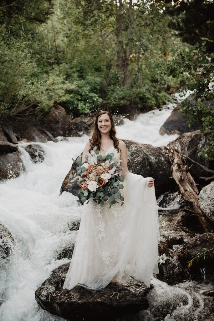 Jackson Hole elopement photographer captures bride holding bouquet and swinging wedding dress