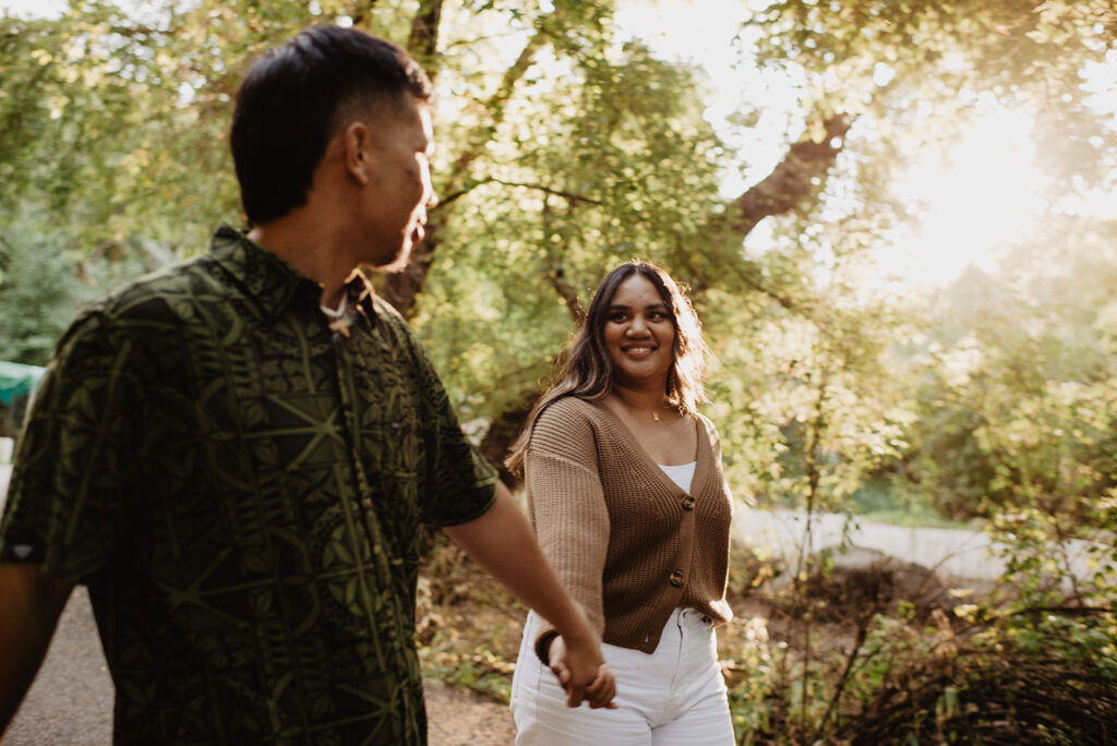 Utah elopement photographer captures couple holding hands and walking during golden hour