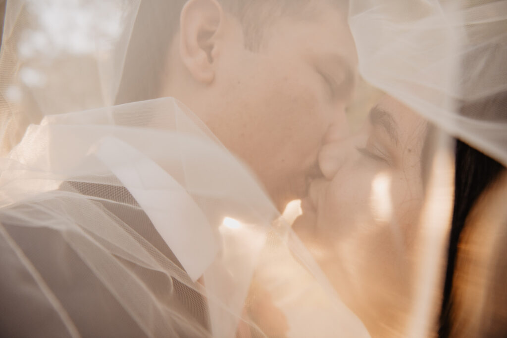 Utah elopement photographer captures bride and groom kissing under veil