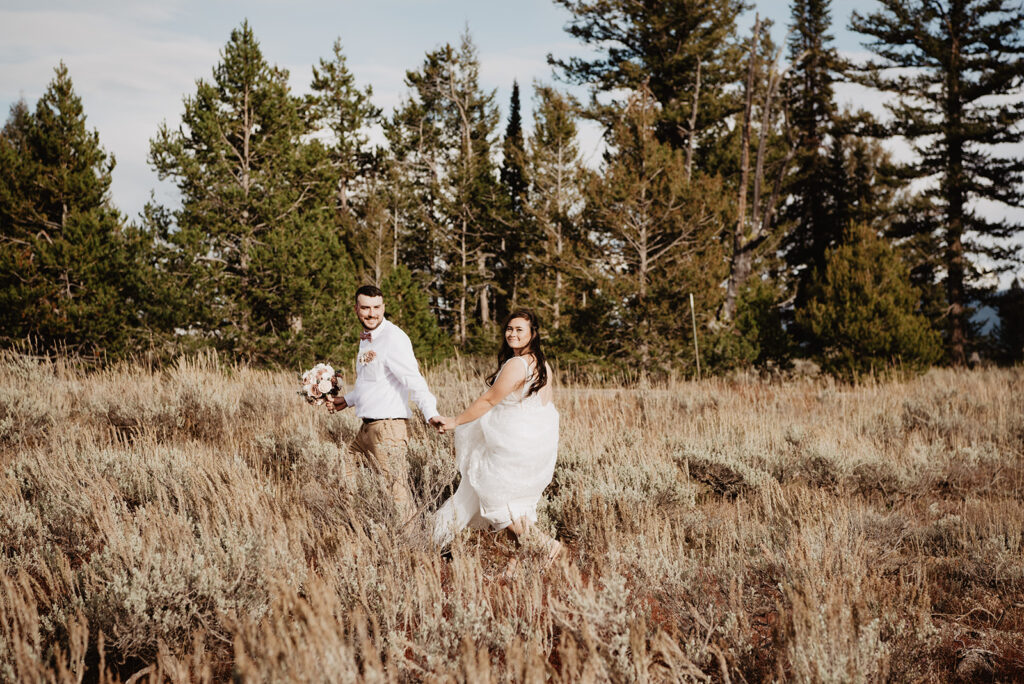 Jackson Wy photographer captures bride and groom walking together holding hands in Grand Teton National Park