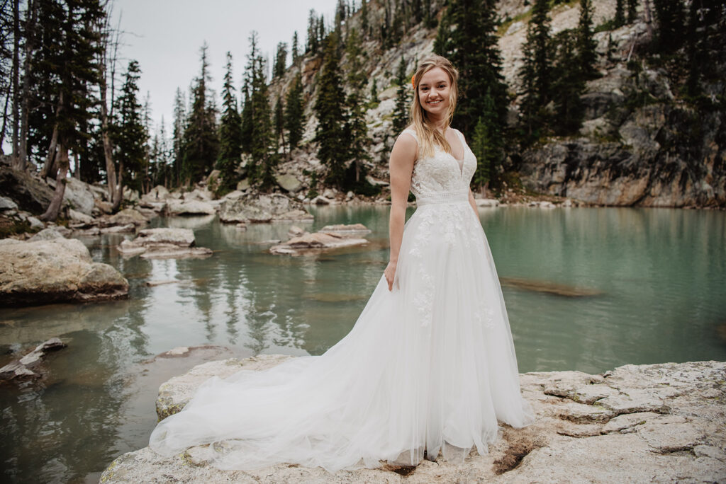 Jackson Wy photographer captures bride standing on beach front wearing wedding dress