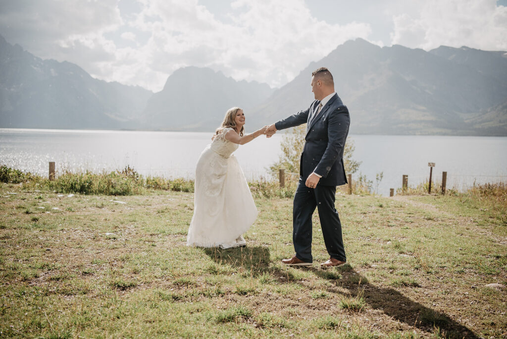 Jackson Wy photographer captures groom spinning bride and dancing together after Grand Teton wedding